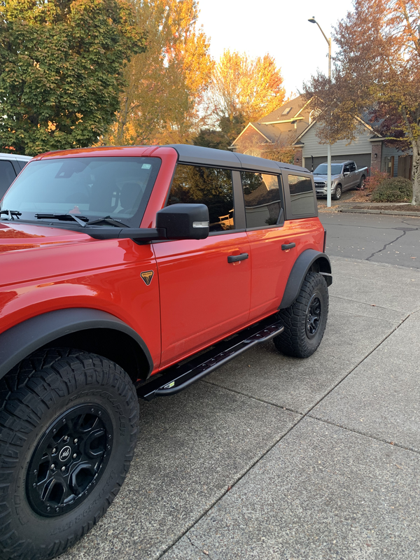 Red 2021 Ford Bronco 4-door with black Metal Tech rock sliders installed on the passenger side.