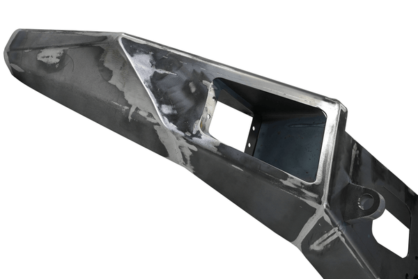 Raw metal front bumper for FJ Cruiser with cutouts and mounting points, angled view.
