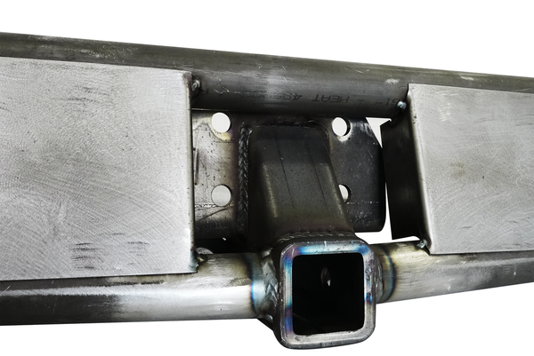 Close-up of raw metal rear tube bumper with welded hitch receiver and mounting plate for FJ Cruiser.
