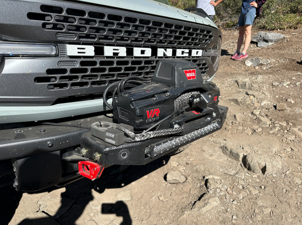 Close-up of Bronco 6G Stronghold winch mount installed on front bumper with Warn VR Evo winch and synthetic rope.