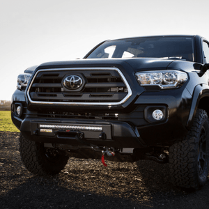 Front view of a black 2016 Toyota Tacoma with a Stronghold winch bumper and LED light bar installed.