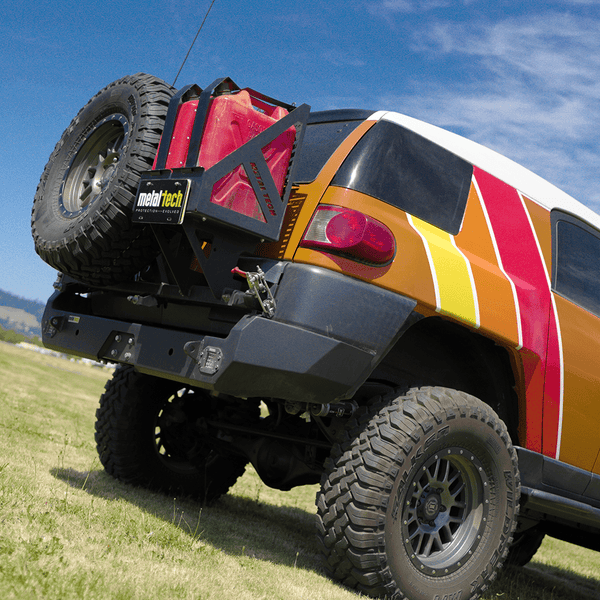 Rear view of FJ Cruiser with Metal Tech Red Eye II full shell swing-out bumper and mounted spare tire and fuel can.