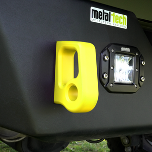 Close-up of yellow aluminum rear bumper pull point with cerakote finish installed on black off-road vehicle bumper.