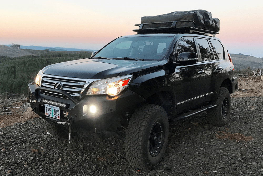 Black Lexus GX460 with installed Metal Tech Talon front shell bumper on grassy field, angled front view.