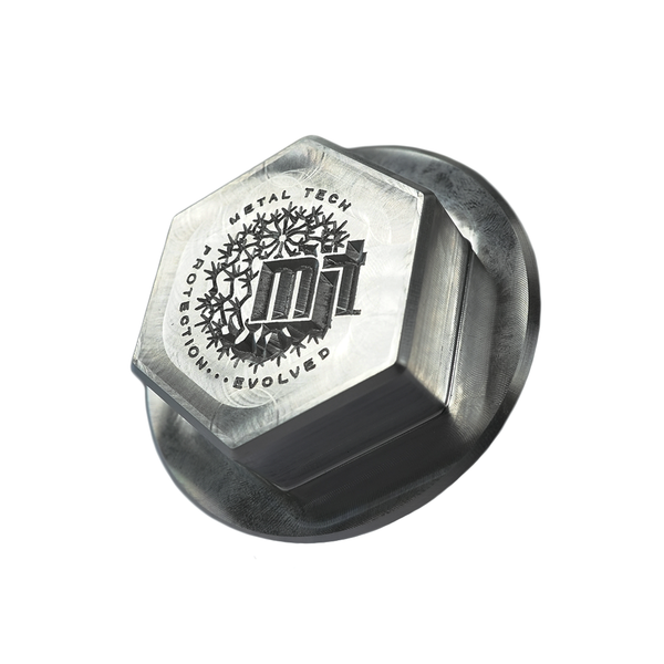 Close-up of a CNC-milled billet metal pivot cap with hexagonal top and engraved Metal Tech logo.