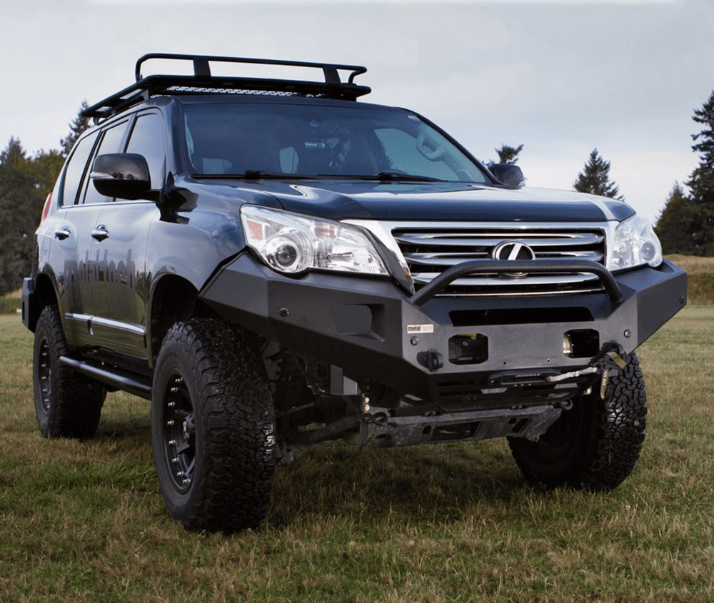 Black Lexus GX460 with installed Metal Tech Talon front shell bumper on grassy field, angled front view.