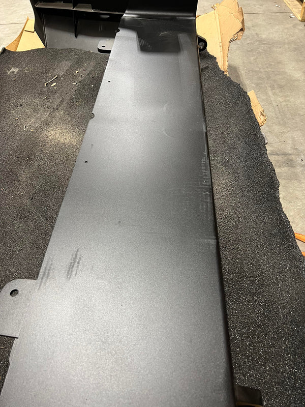 Close-up of flat black metal panel for Lexus GX460 Stage 1 Lancer rear bumper, resting on foam padding.