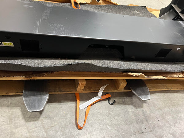 Close-up of black SD Metal Tech rear bumper for 2010 Lexus GX460, showing mounting cutouts and textured finish.