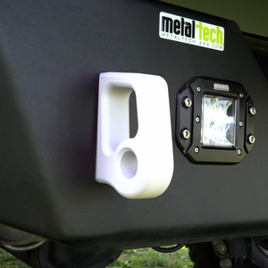 Close-up of white aluminum rear bumper pull point with Cerakote finish installed on black bumper next to LED light.